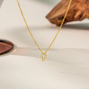 Detailed view of the gold titanium cross necklace with white shell inlay for women