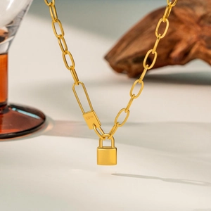 Detailed close-up of a golden padlock necklace with LOVE engraving and paperclip chain