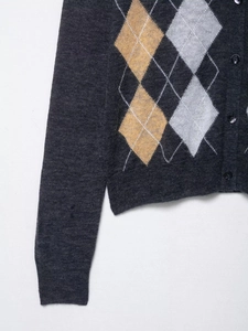 Close-up of dark grey argyle cardigan showing yellow and white diamond knit patterns