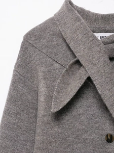 Close-up of grey wool coat texture with a premium amber-patterned button detail