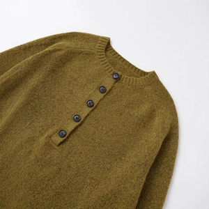 Olive green crew neck knit sweater with buttoned placket in a soft autumn winter texture