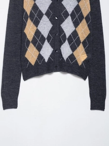 Detail of grey argyle knit cardigan with yellow diamond patterns and ribbed cuffs
