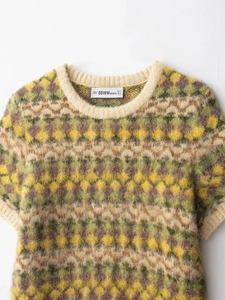 Close-up of the crew neck and argyle jacquard pattern on this fuzzy short sleeve knit top