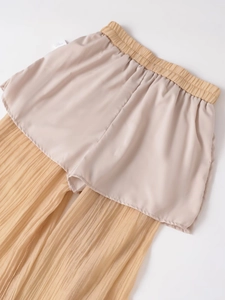 Detail showing elastic waistband and pleated fabric texture on beige wide leg trousers