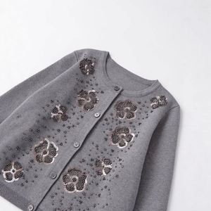 Grey knit cardigan with handmade floral sequins and bead embellishments in a flat lay view