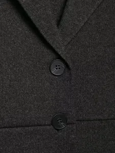 Close-up of deep gray knit texture and black button detail on V-neck sleeveless vest