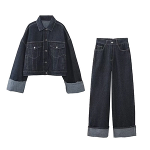 Détails de l'ensemble en denim noir avec surpiqûres contrastées sur veste et pantalon