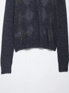 Detailed macro shot of dark grey knit cardigan showing ribbed hem and sleeve cuffs texture