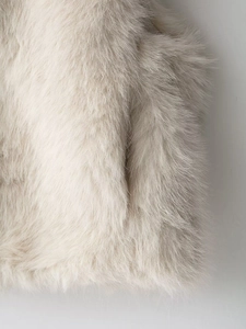 Close-up of fluffy faux fur texture in cream beige with soft fibers and smooth gloss finish