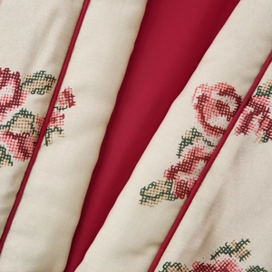 Floral cross-stitch pattern on beige cotton kimono jacket with red piping detail