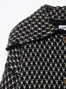 Detail of checkered knit cardigan with large lapel and dark brown buttons on fabric