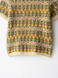 Close-up of retro argyle knit top with fuzzy mohair texture and ribbed trims