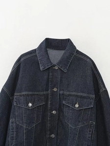 Détail de la veste en jean bleu foncé avec boutons en métal et poches cargo