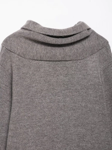 Close-up of a grey chunky knit sweater neckline featuring a soft wool-like texture