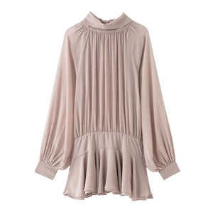 Detail of dusty pink pleated chiffon blouse featuring a high ruffled neck and flared hem