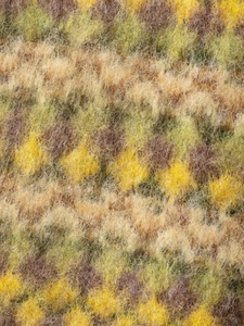 Macro shot of fluffy jacquard knit fabric with brushed fibers in yellow and olive green
