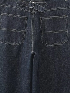 Détail de jeans en denim foncé avec poches arrière et sangle réglable à anneaux en D