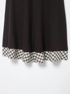 Detail of twill knit fabric and black and white plaid stitching on the dress hemline