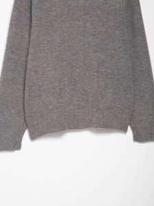 Close-up of ribbed cuffs and hem on a high-quality dark grey knitted sweater