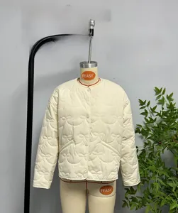 Close-up of cream quilted jacket featuring unique bow-shaped stitching and button detail