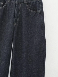 Détail de jean taille haute bleu foncé avec coutures contrastées blanches et poches