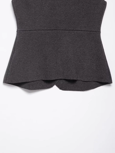 Detail of slim-fit dark grey knitted vest featuring waist cinching and curved hemline