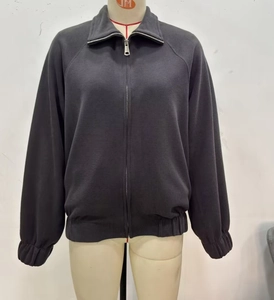 Detail of dark grey zip-up hoodie featuring a stand collar and metallic silver zipper