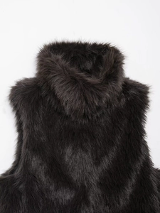 Detail of high neck faux fur vest in dark brown with thick plush texture and glossy finish