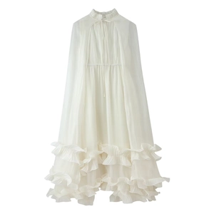 Detail of white long sleeve dress featuring tiered ruffle hem and frill neckline ties