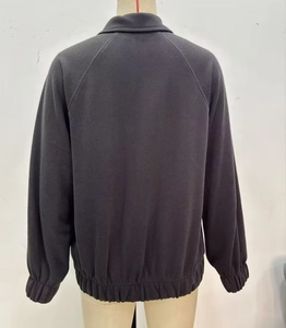 Back view of a charcoal grey raglan sleeve zip-up sweatshirt with ribbed cuffs and hem