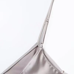Détail de robe en satin argenté avec bretelles réglables et dentelle délicate