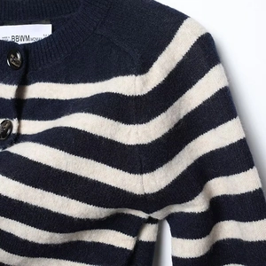 Detail of blue and white striped knit cardigan showing round neck and textured buttons