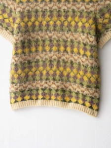 Close-up of vintage argyle knit vest featuring fuzzy mohair texture and ribbed trims