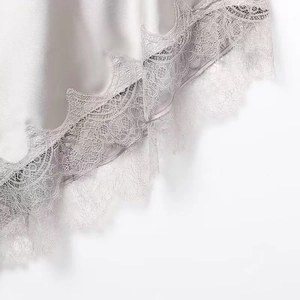 Détail d'une robe en satin gris avec bordure en dentelle cil et texture soyeuse