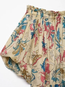 Close-up detail of ramie floral print fabric with elastic smocking and beige texture