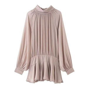 Detail of mauve pleated high-neck blouse with elegant lantern sleeves and ruffled hem
