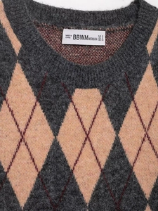 Detalle de chaleco de punto con rombos mostrando el cuello redondo y textura suave