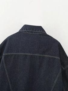 Détail de la veste en jean bleu foncé avec surpiqûres contrastées et tissu sergé robuste
