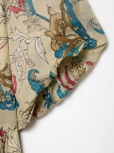 Detailed macro view of retro floral print on lightweight ramie fabric with pleated sleeve cuff
