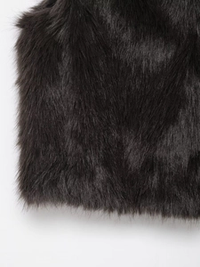 Close-up detail of soft black faux fur texture on a warm winter vest garment