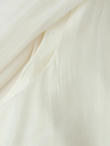 Close-up of fine sewing detail and vertical pleated texture on white chiffon dress