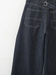 Détail du dos d'une veste en jean bleu foncé avec grandes poches et boucle de réglage