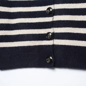 Close-up of black and white striped knit cardigan with textured amber resin buttons