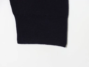 Detail of navy blue ribbed cuffs on a knitted polo sweater with fine textured fabric