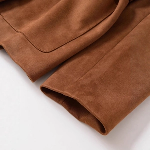 Close-up of brown suede cardigan showing pocket stitching and fine fabric texture