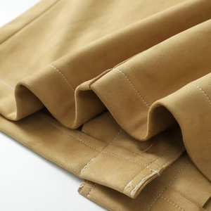 Close-up of khaki suede jacket fabric with white double-needle stitching detail