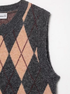 Detalle de chaleco de punto de rombos con patrones gris y rosa y textura suave