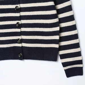 Close-up of striped knit cardigan showing soft wool texture and black button detail