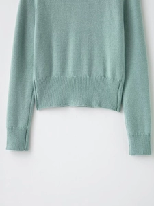 Detail of mint green knit cardigan featuring ribbed hem and side slit design