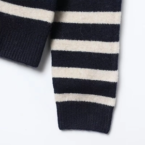 Detailed macro view of the soft striped knit fabric and ribbed cuffs on the cardigan